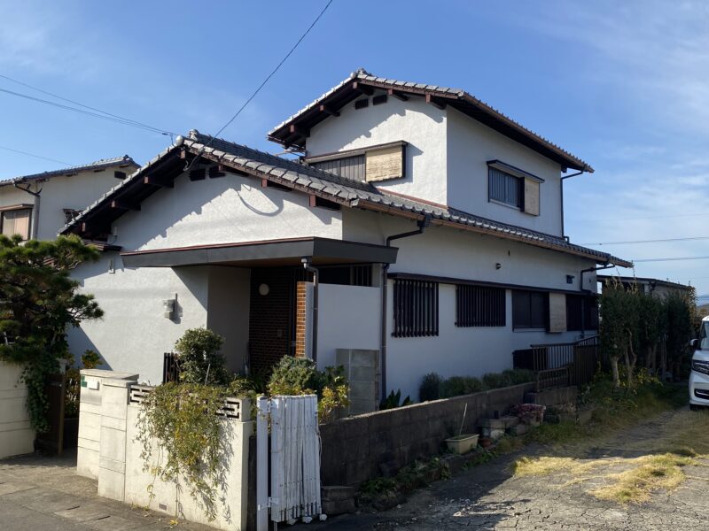 太宰府市青山のI様邸にて、外壁と屋根の塗装工事を始めました。
「外壁の汚れが気になってきて、家全体が古く見えるようで…」とご相談をいただきました。大切なお住まいの印象に関わる部分ですので、そのお気持ちとてもよくわかります。

現地を確認すると、外壁の塗膜が紫外線で劣化し、色あせやチョーキング現象が見られました。屋根も全体的に防水性が低下し、雨水を弾きにくい状態でした。

まずは高圧洗浄でしっかりと汚れや旧塗膜を落とし、下地を整えます。その後、下塗り・中塗り・上塗りの3工程で塗膜を重ね、外壁・屋根ともに耐候性と防水性を高めていきます。

I様に「きれいが長持ちする仕上がり」を実感していただけるよう、一つひとつの工程を丁寧に行ってまいります。足場作業中は安全確保を最優先に、お出かけの際も安心して通行いただけるよう配慮しながら進めていきます。